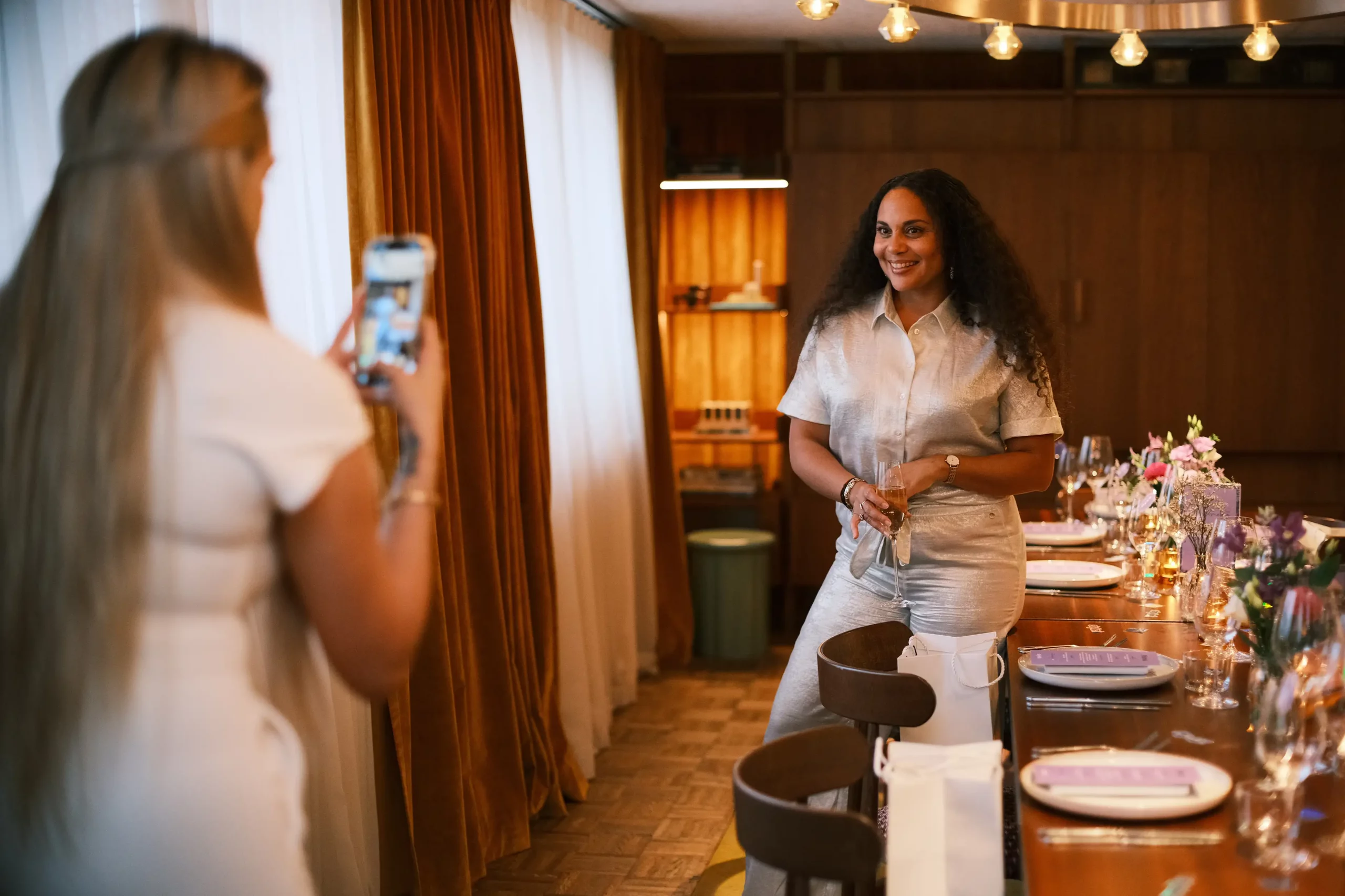Mädchen fotografiert eine andere an einem gedeckten Tisch für Gäste
